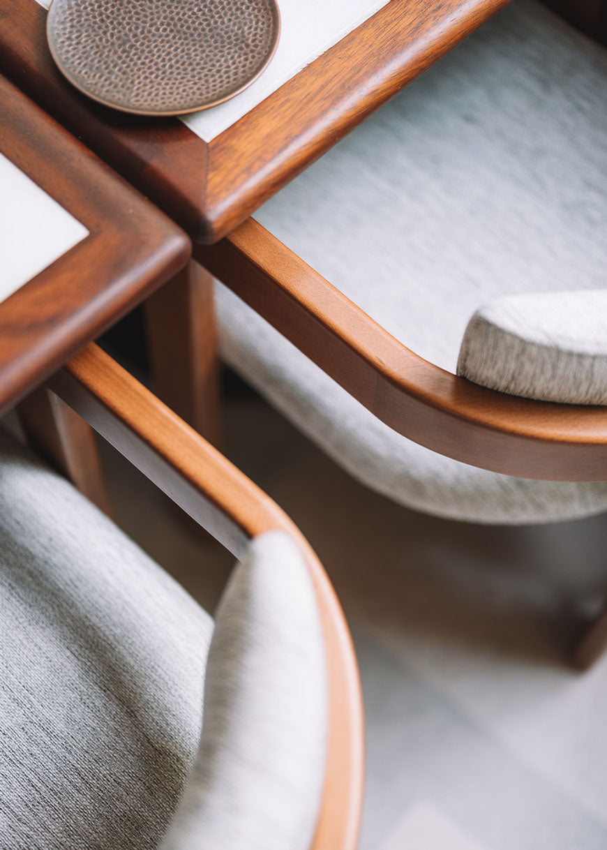 Silla de madera de haya con reposabrazos tapizada en tela jaspeada.