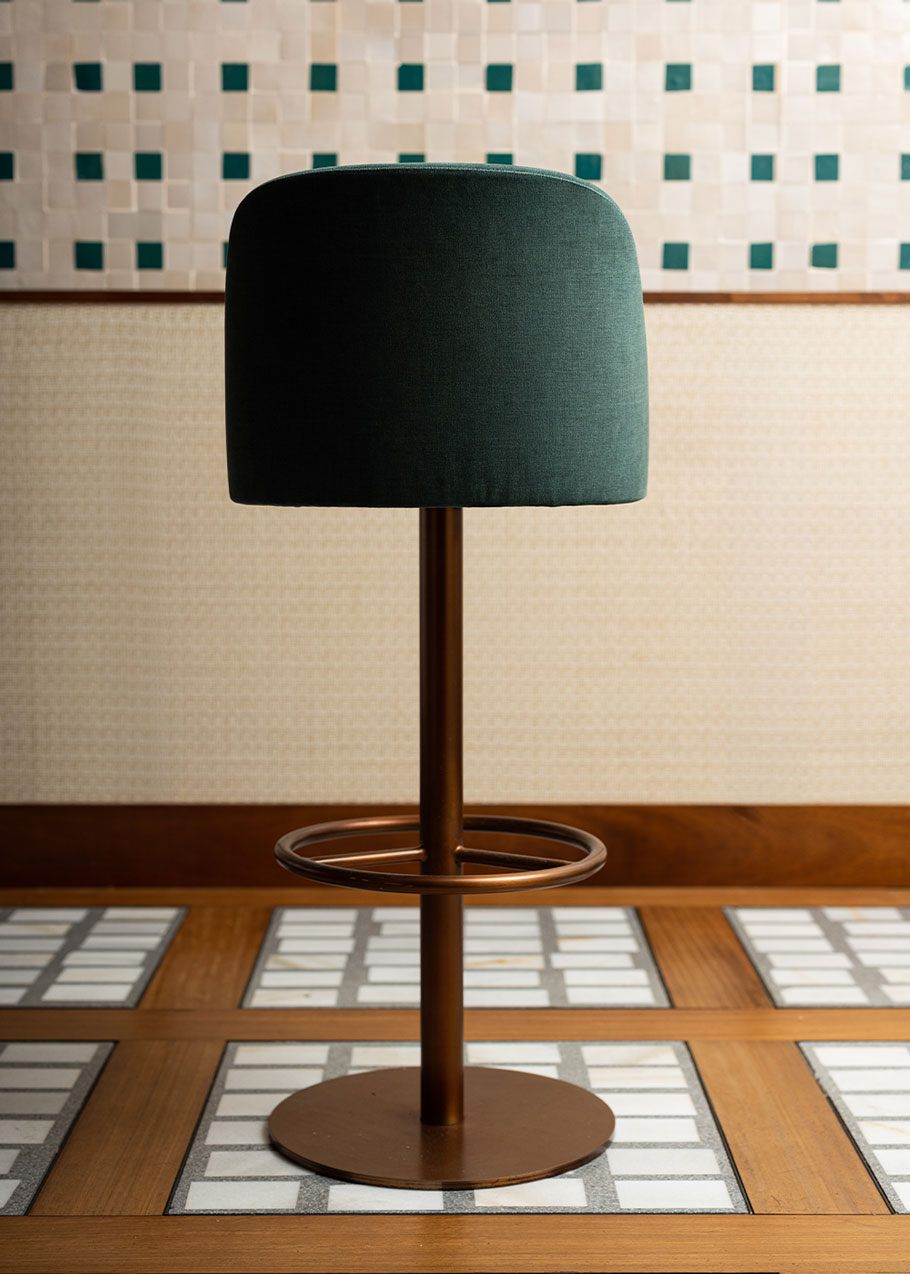 Taburete tapizado con estructura de hierro acabado en oro rosa.