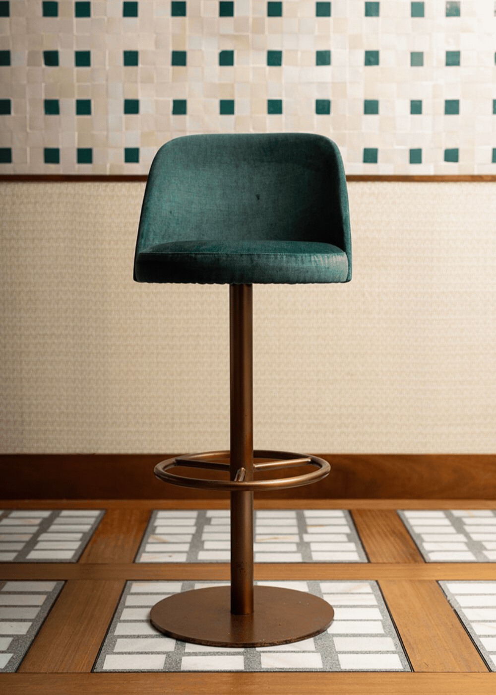 Taburete tapizado con estructura de hierro acabado en oro rosa.