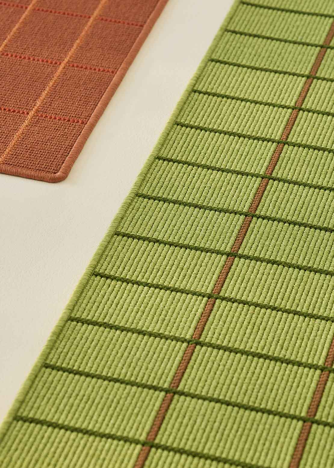 Alfombra fabricada en PET a partir de botellas de plástico recicladas de color verde pistacho en telar wilton de tejido plano.