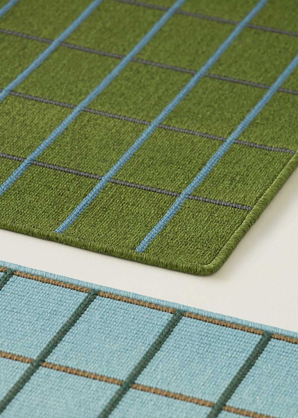 Alfombra fabricada en PET a partir de botellas de plástico recicladas de color verde oscuro en telar wilton de tejido plano.