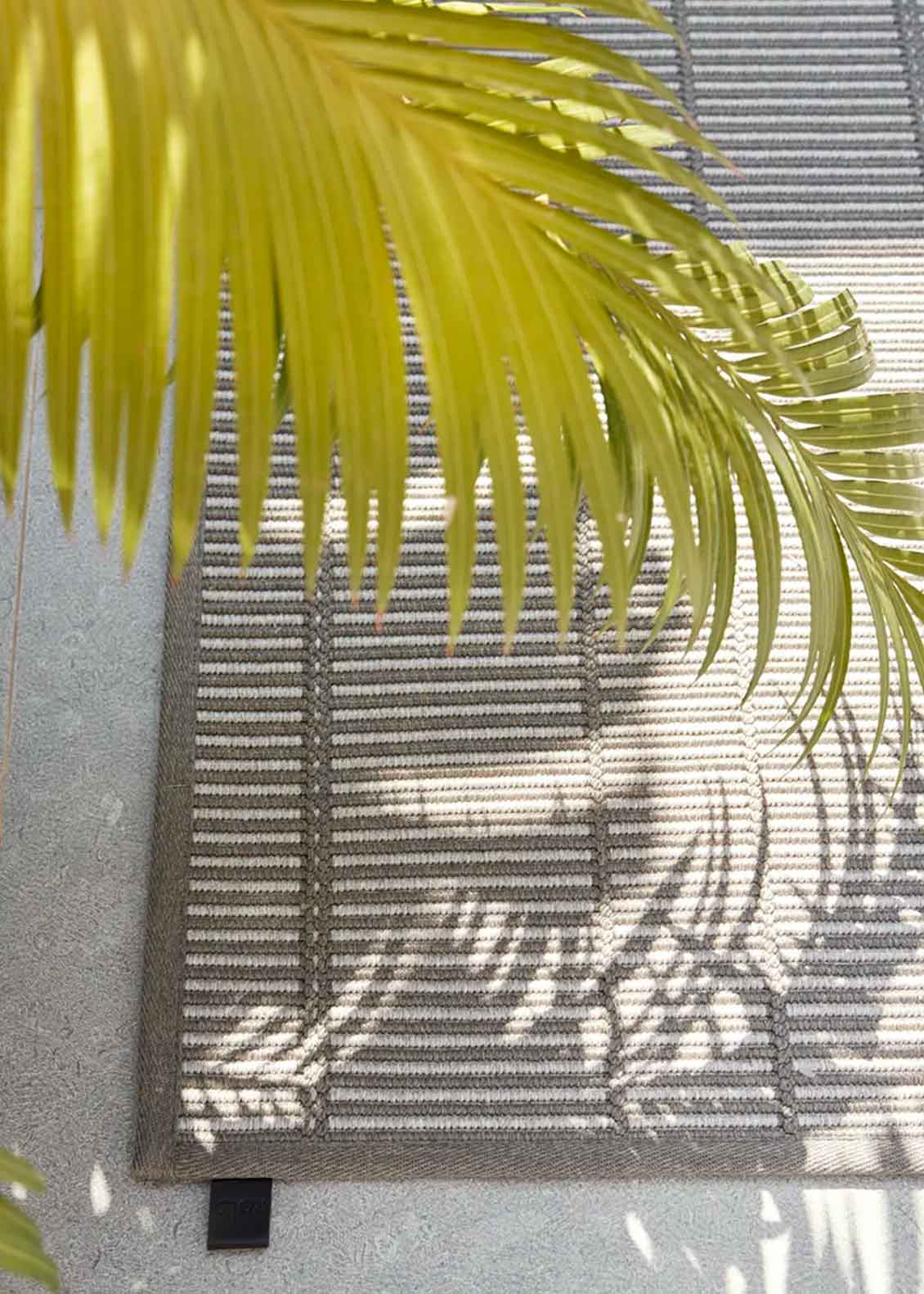 Alfombra fabricada en PET a partir de botellas de plástico recicladas de color gris en telar wilton de tejido plano.
