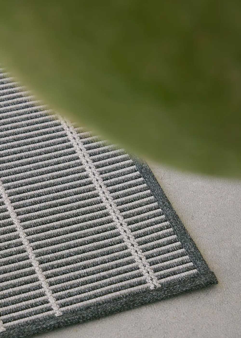 Alfombra fabricada en PET a partir de botellas de plástico recicladas de color gris azulado en telar wilton de tejido plano.