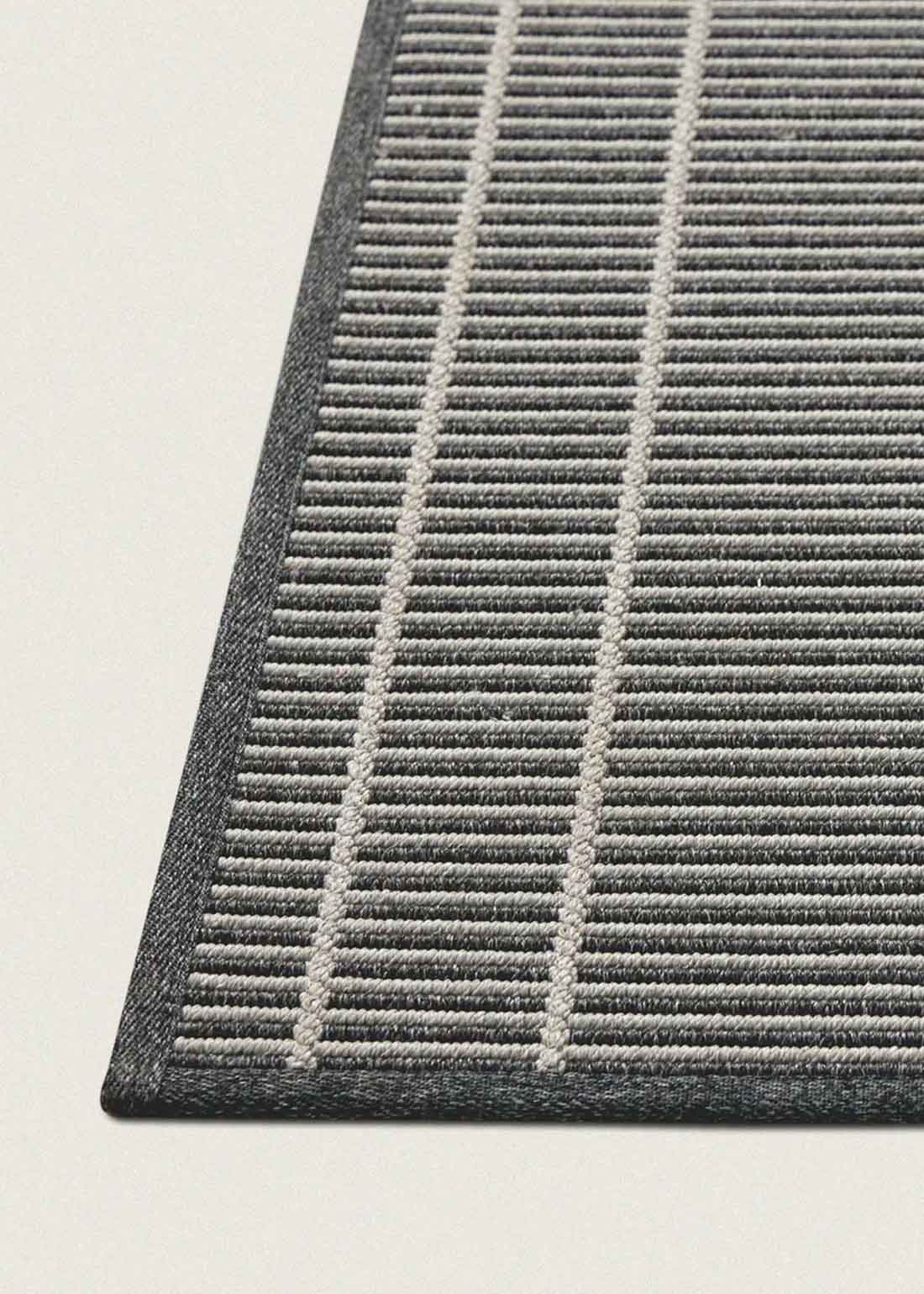 Alfombra fabricada en PET a partir de botellas de plástico recicladas de color gris azulado en telar wilton de tejido plano.