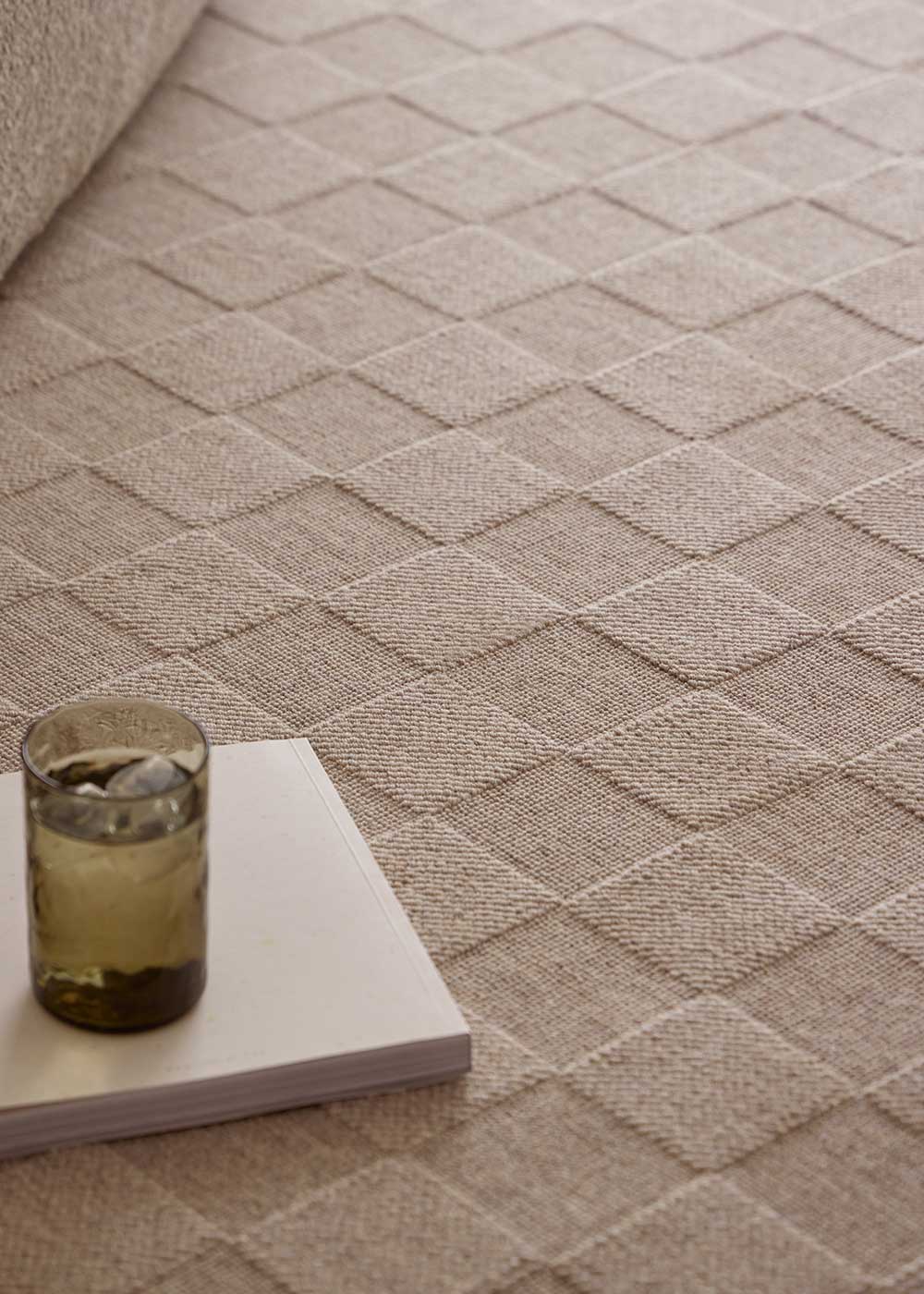 Alfombra fabricada con lana de color topo en telar wilton con superficie en bucle con saltillo.