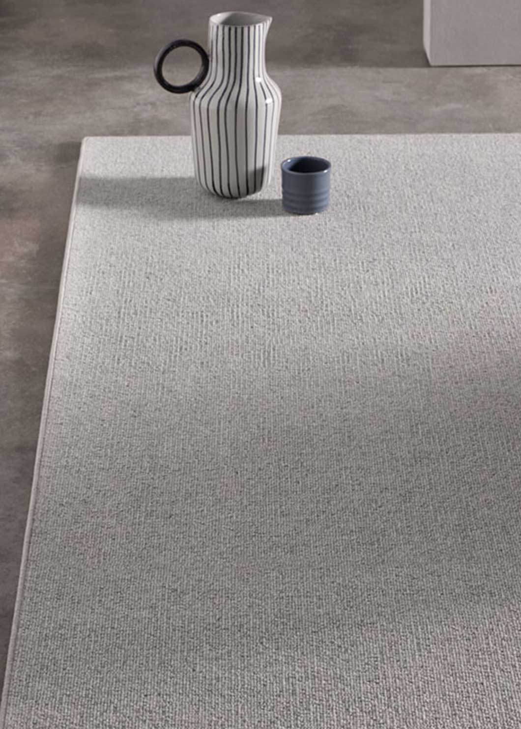 Alfombra fabricada con lana de color gris celeste en telar tufting con superficie en bucle.