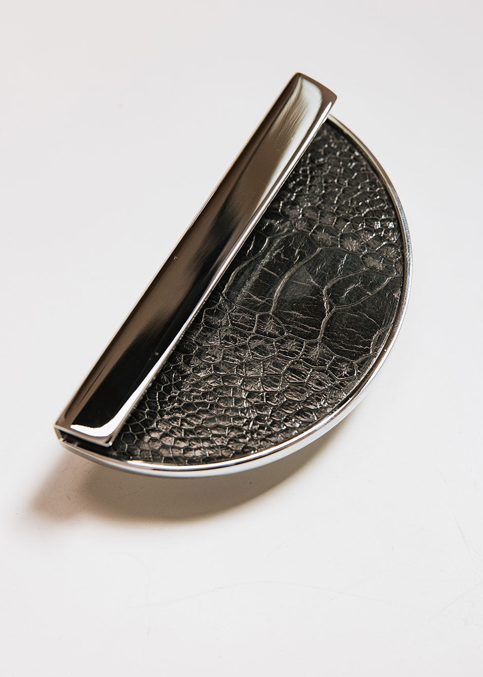 Crescent-shaped metal handle wrapped in ostrich leg leather