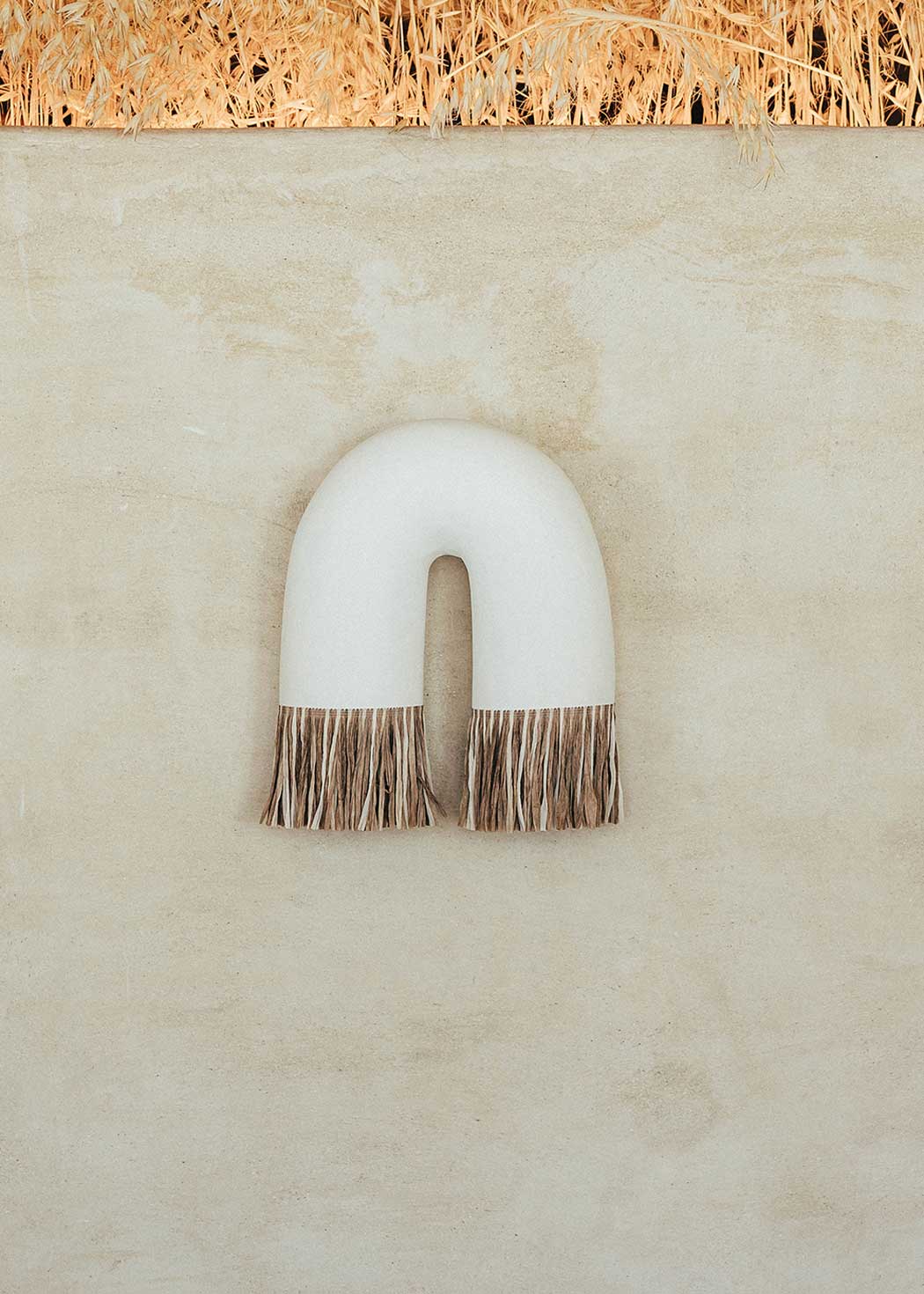 Aplique de pared curvado realizado en escayola con acabado semicrudo.