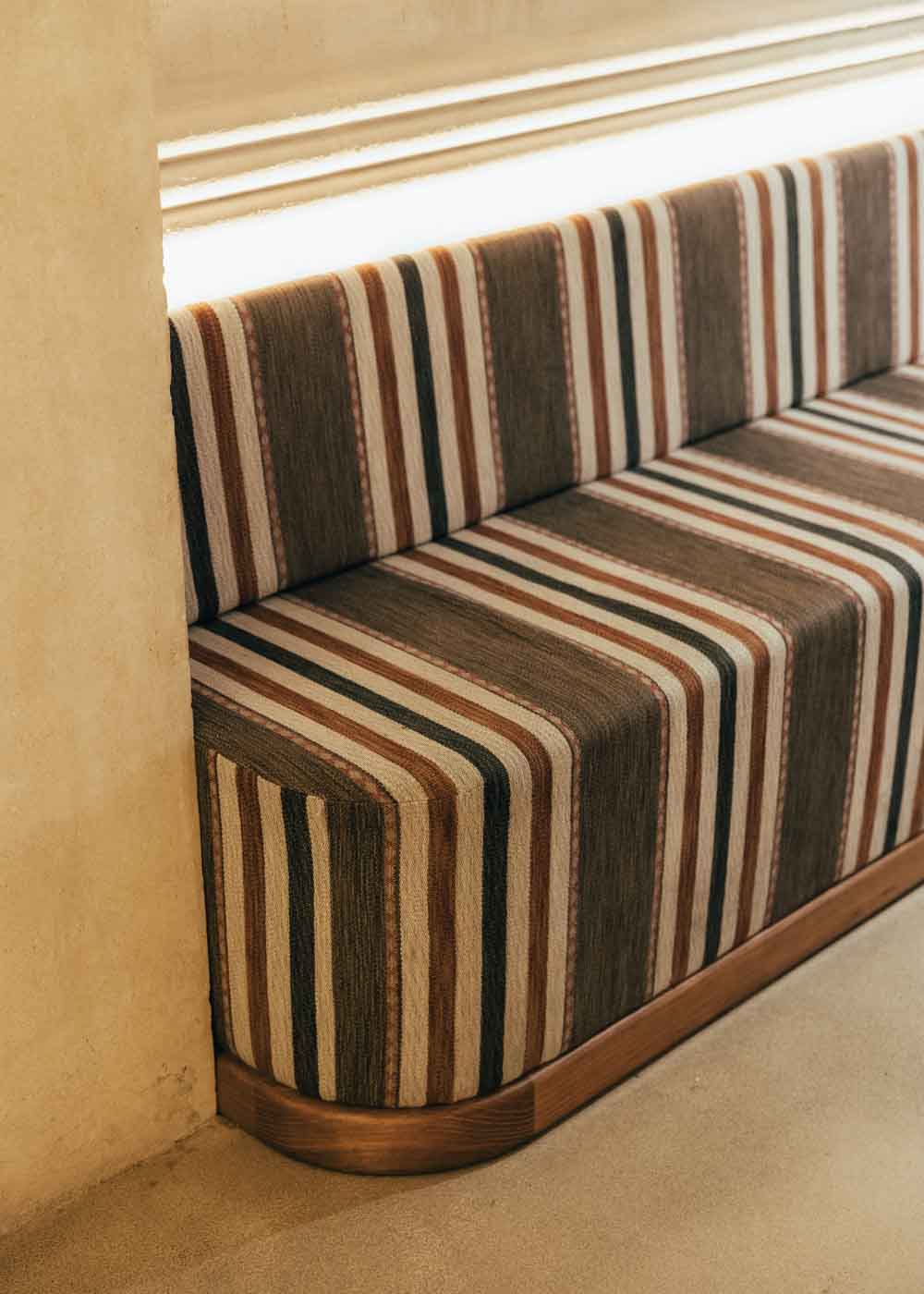 Banco de madera tapizado con tela de rayas