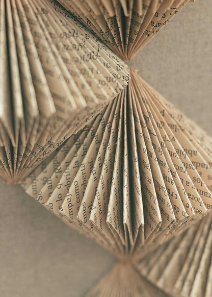 Escultura de pared forrada en lino rústico con caja de metacrilato transparente y serie de libros plegados.