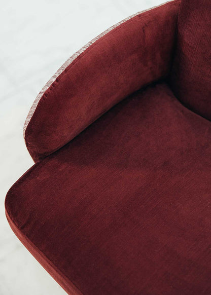Butaca con estructura de madera tapizada en dos telas, un terciopelo color caldero y una tela jaspeada en tonos beige y caldero.