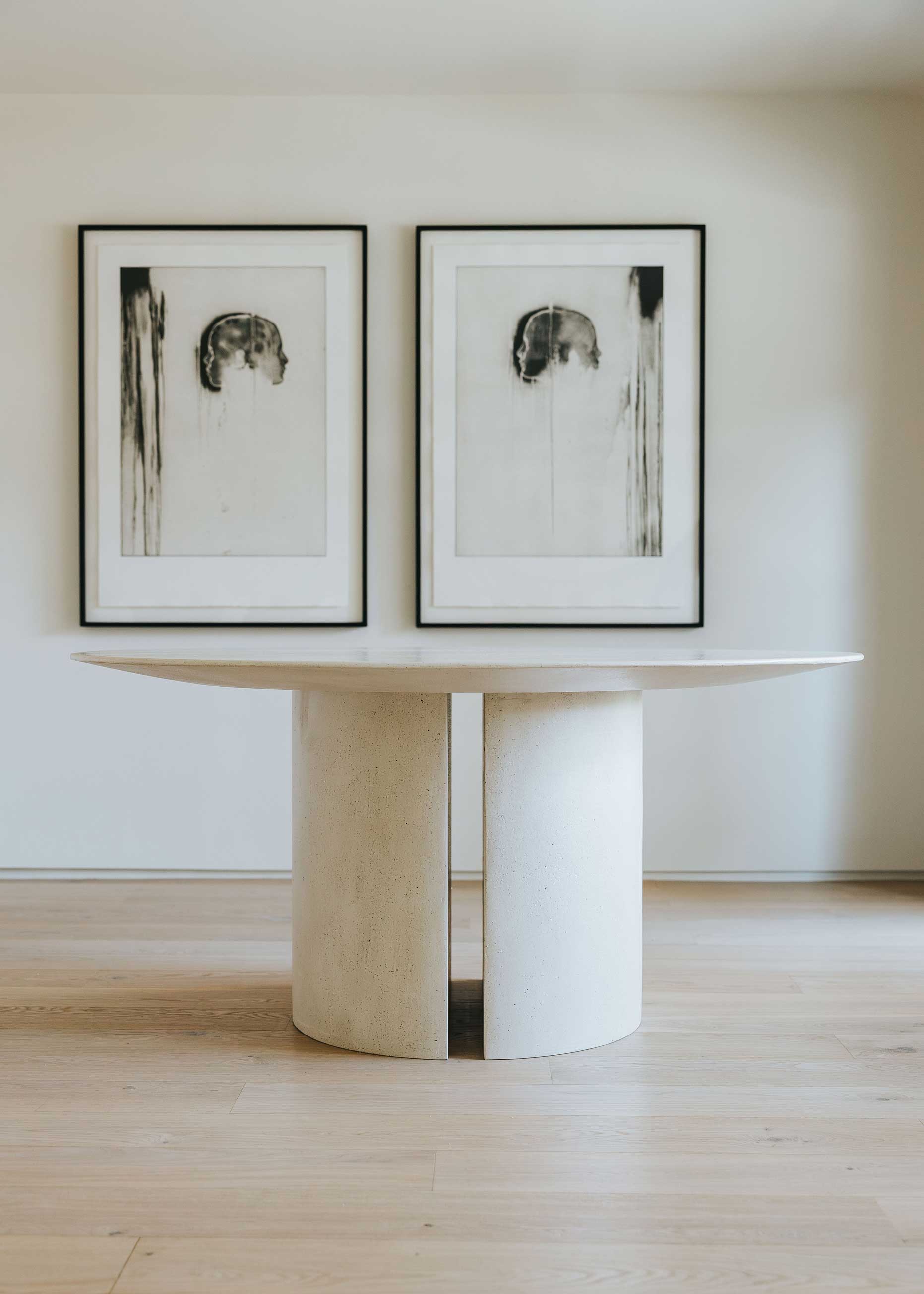 Mesa de comedor circular con estructura de madera revestida con microcemento.