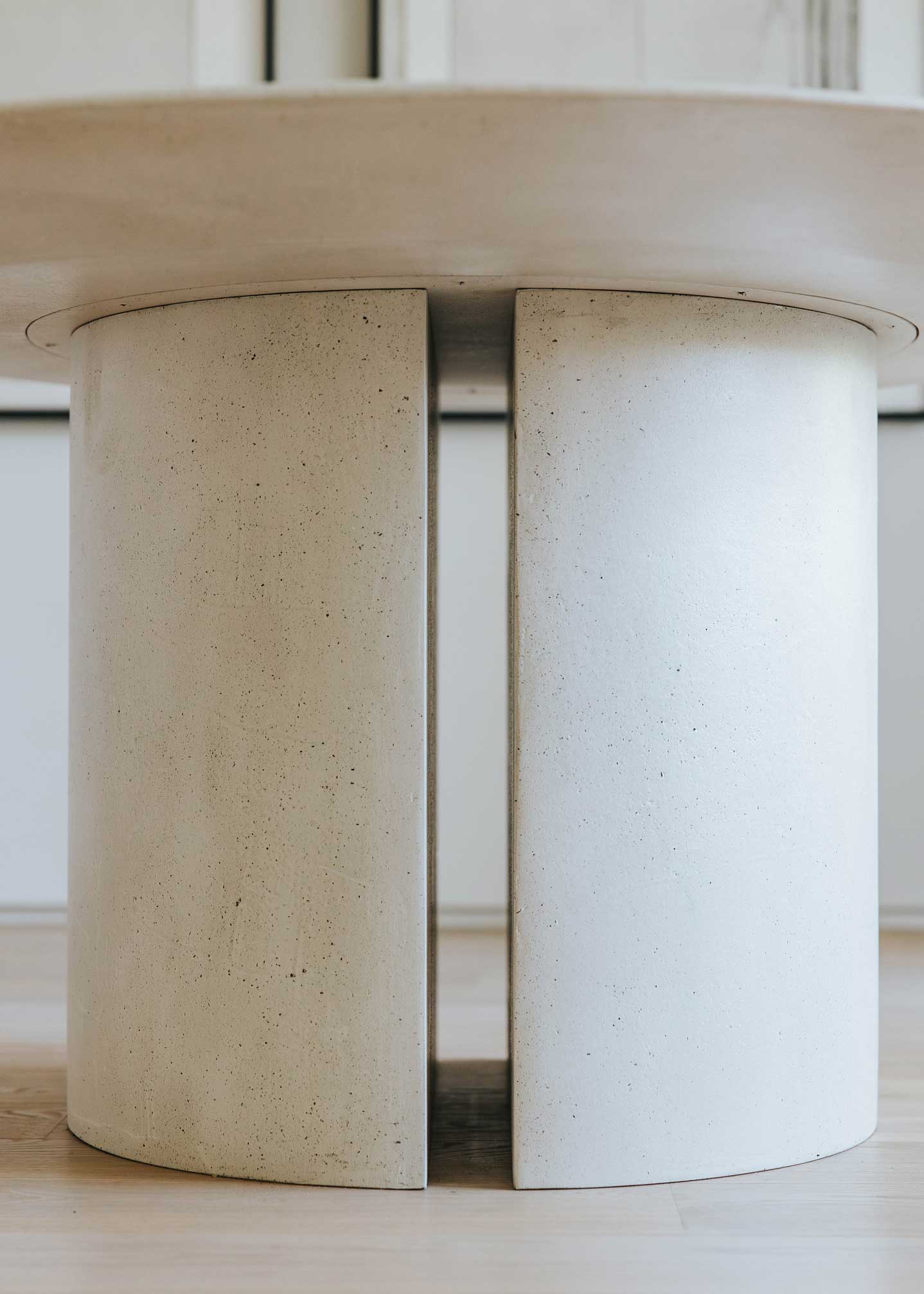 Mesa de comedor circular con estructura de madera revestida con microcemento.