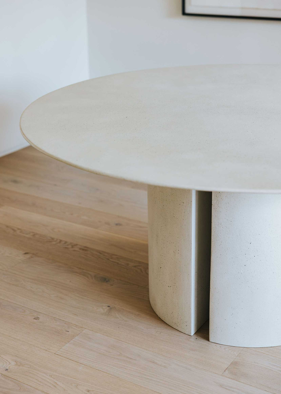 Mesa de comedor circular con estructura de madera revestida con microcemento.