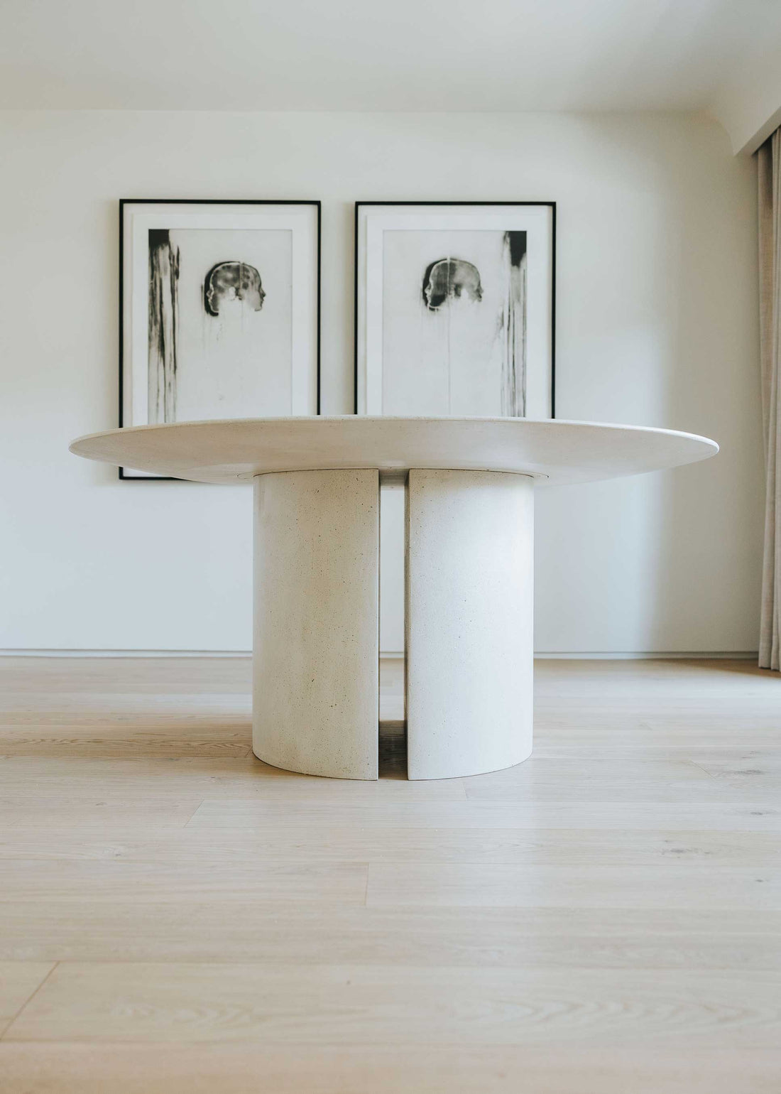 Mesa de comedor circular con estructura de madera revestida con microcemento.