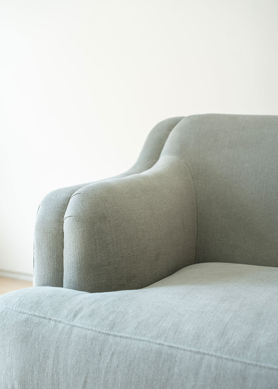 Sofá tapizado en tela gris de lino y algodón con estructura de madera de haya.