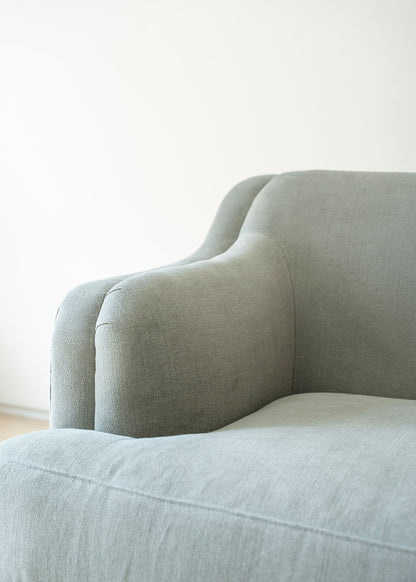 Sofá tapizado en tela gris de lino y algodón con estructura de madera de haya.