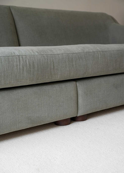 Sofá tapizado en tela gris de lino y algodón con estructura de madera de haya