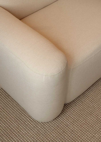 Sofá con estructura de madera tapizado en tela de terciopelo marrón verdoso o tela blanca cruda.