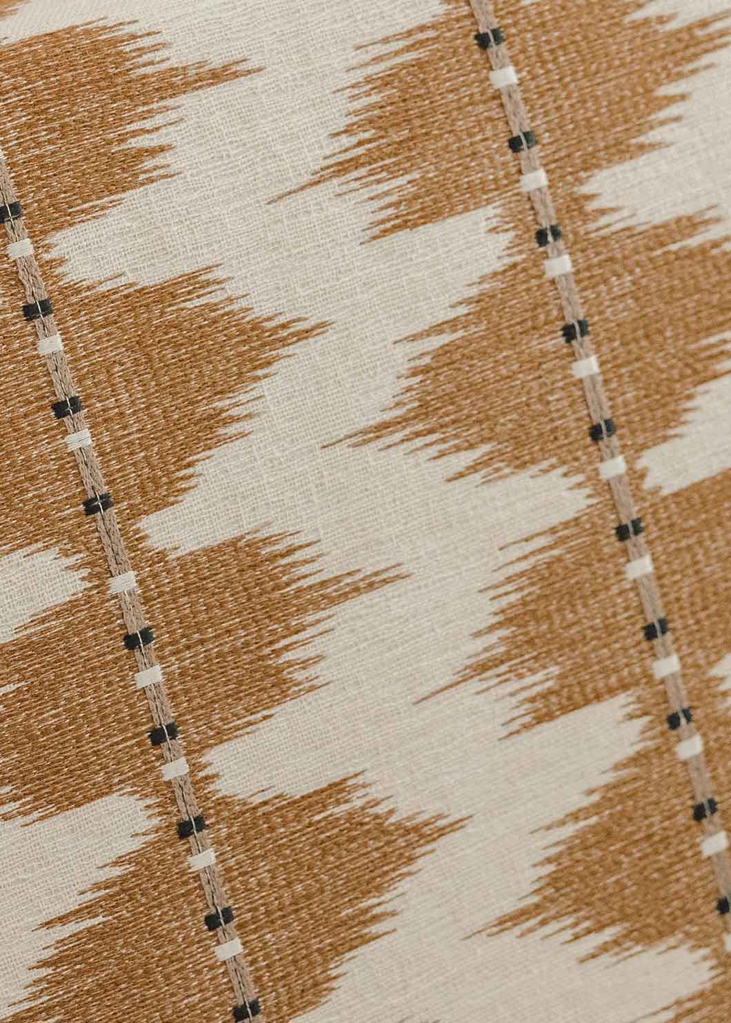 Cabecero tapizado con tela estampada en tonos ocres y crudos.