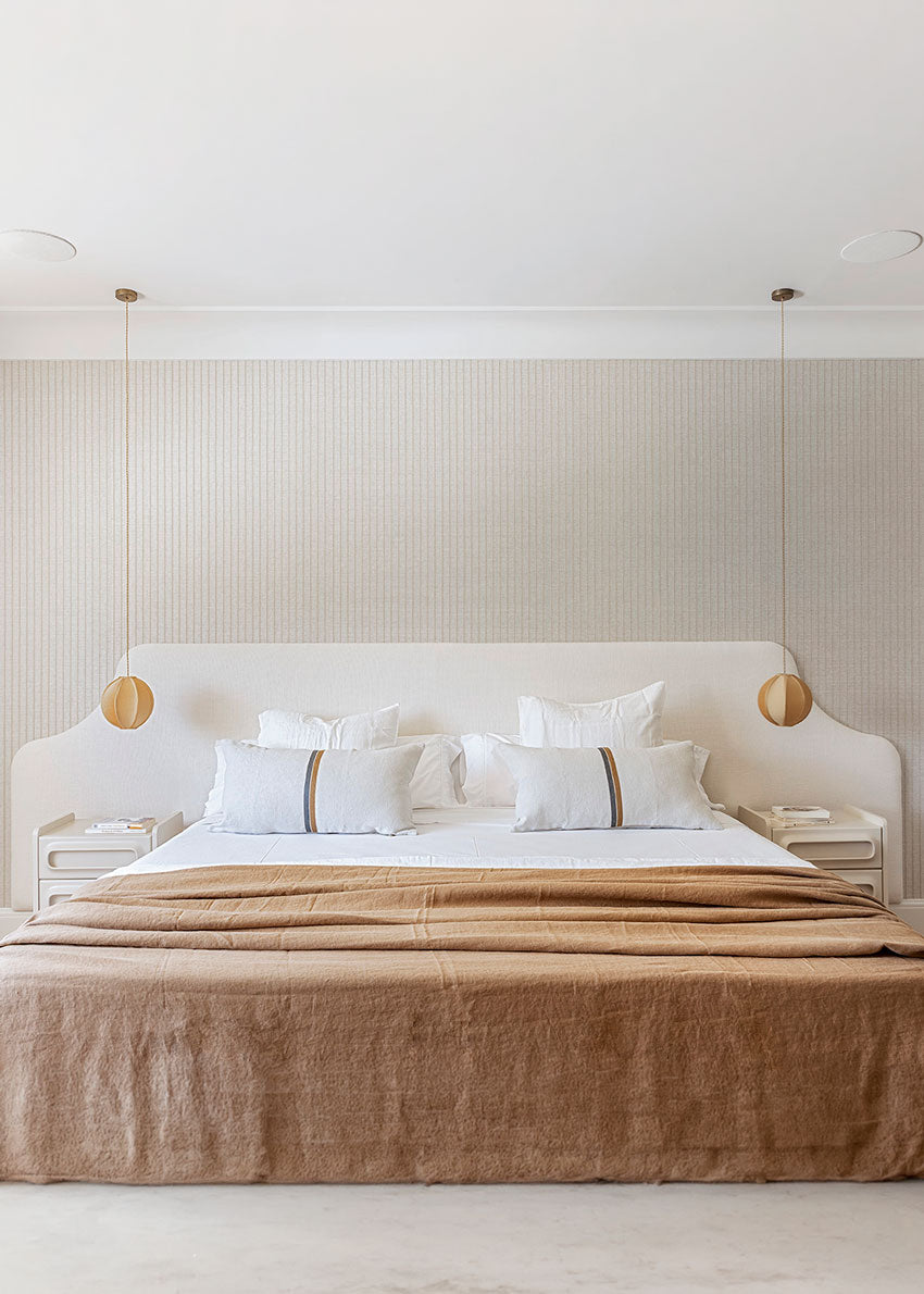 Cabecero tapizado en tela blanca.