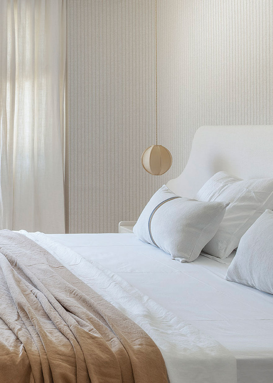 Cabecero tapizado en tela blanca.