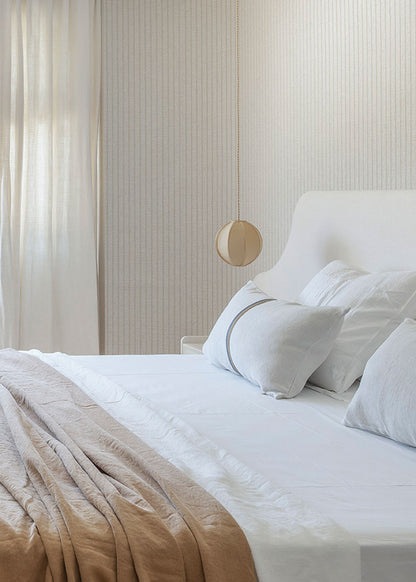 Cabecero tapizado en tela blanca.