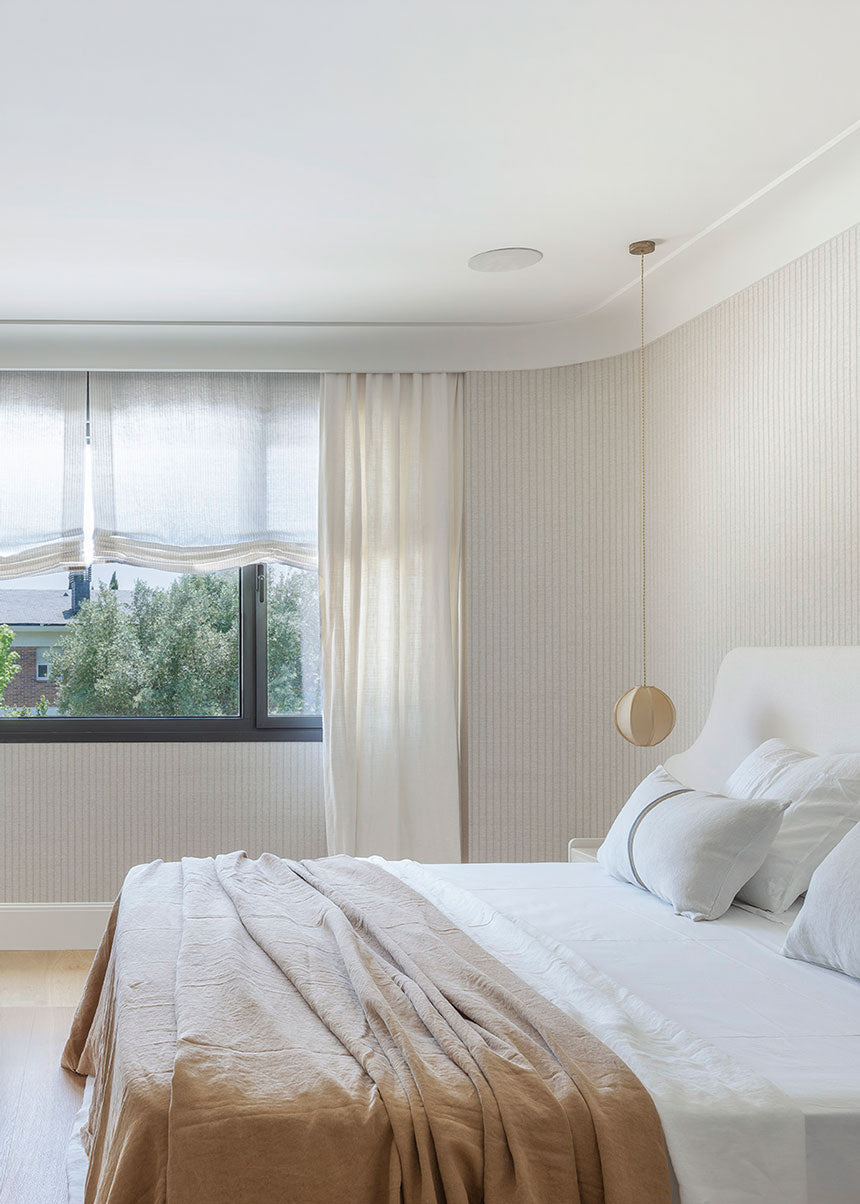 Cabecero tapizado en tela blanca.