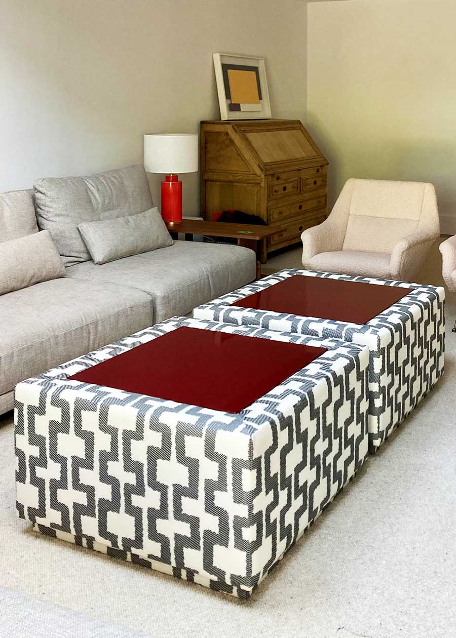 Mesa de centro tapizada con con tela de estampado geométrico y superficie en madera lacada