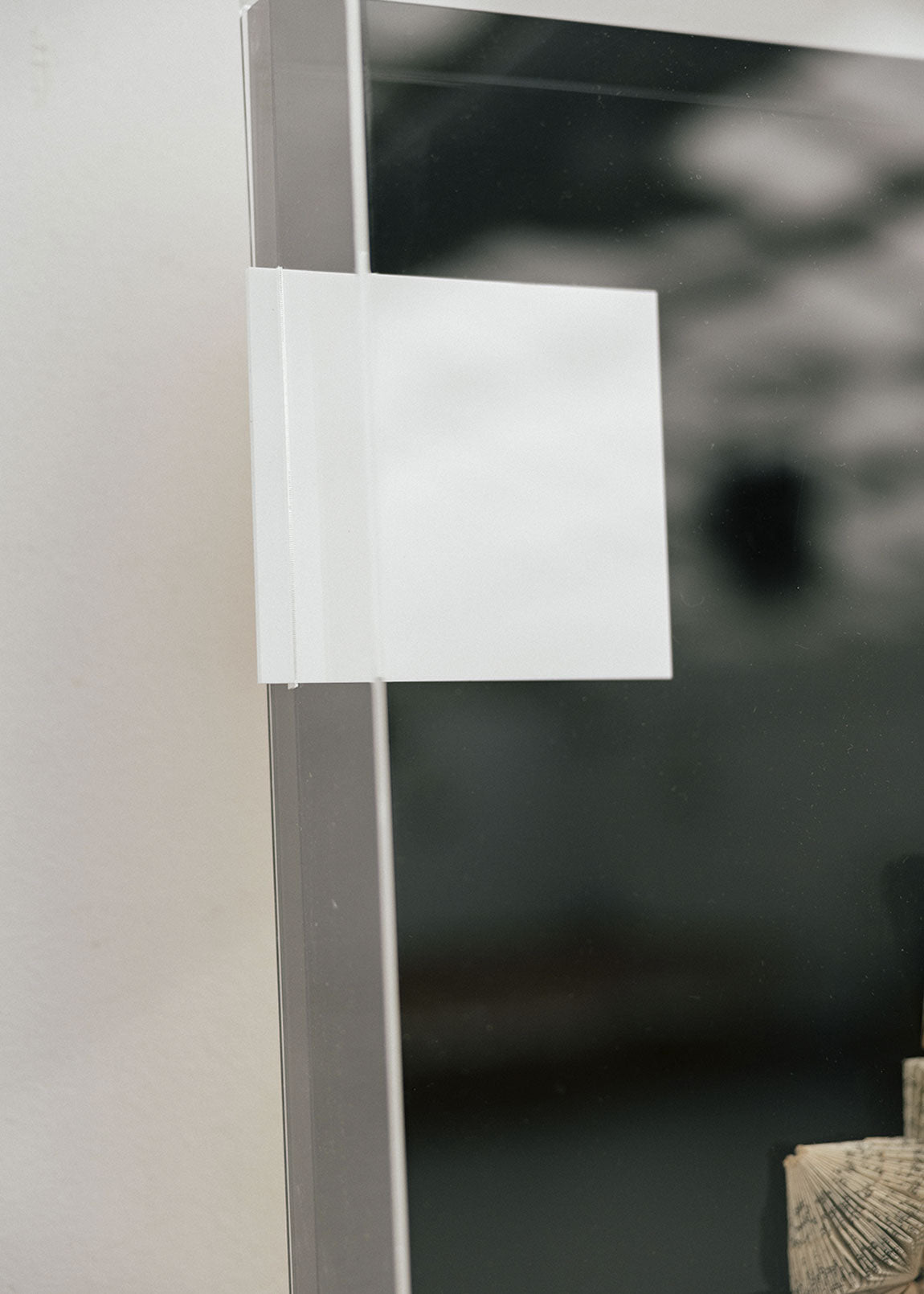 Escultura de pared forrada en metacrilato negro y blanco con caja de metacrilato transparente y serie de libros plegados.