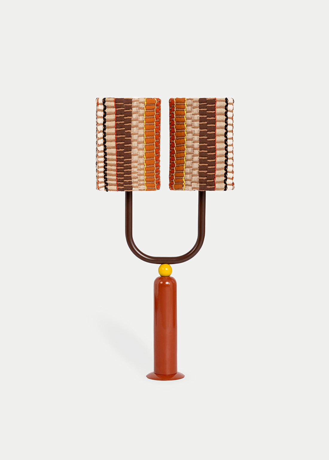 La lámpara N03 transporta a Tánger, ciudad donde empezó esta colección. Su base recuerda a los candelabros marroquíes, milimétricamente diseñados en torno en color arcilla, combinada con una mini bola mostaza y una media circunferencia en color chocolate.