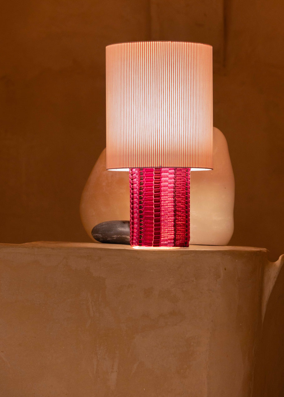 La lámpara N05 es una explosión de color. Perfecta para dar un toque de diversión y diseño a cualquier espacio. Con una base cubierta de tejido hecho en telar, combinando sedas, linos y diferentes texturas y una maxi pantalla de tejido de oxford de rayas rosas.