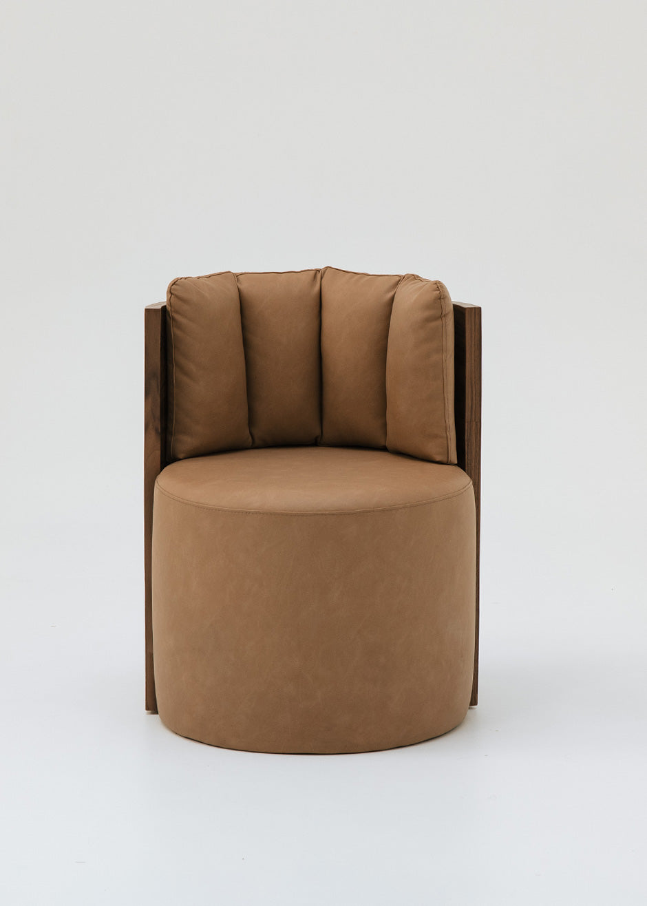 Butaca redonda con estructura de madera tapizada en dos telas, una de color beige para el asiento y una tela una polipiel camel para el respaldo.