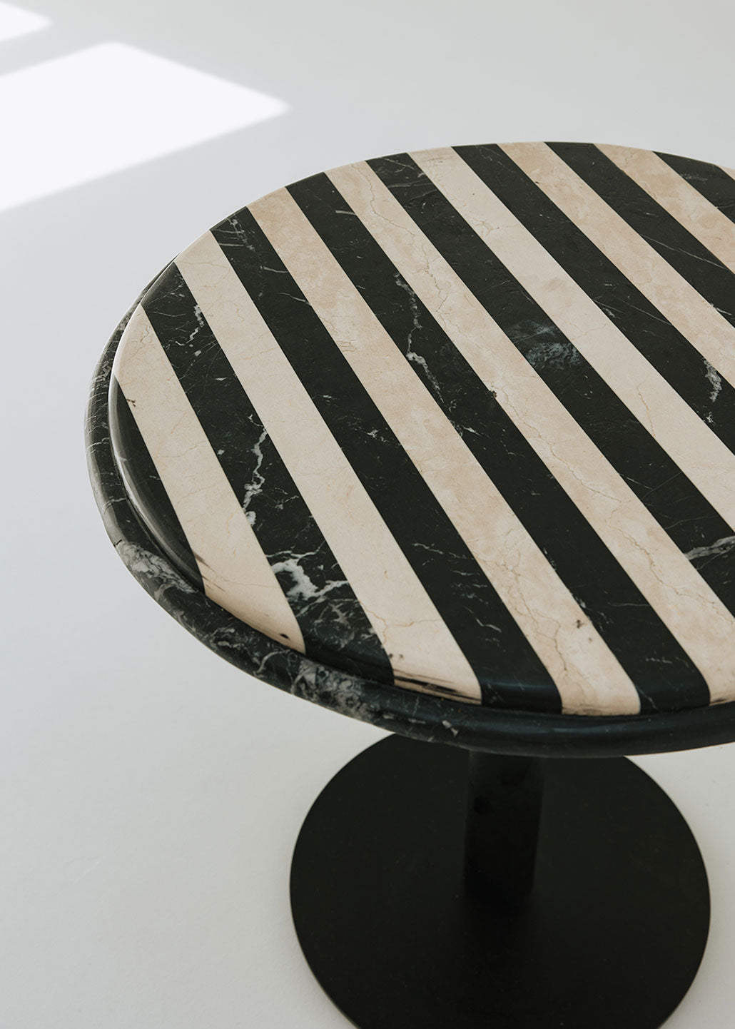 Mesa de comedor redonda con estructura metálica con acabado en negro y doble sobre.