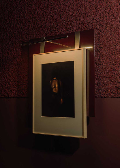 Portacuadros de acero lacado con pletinas de acero cepillado con aplique sobre cuadro integrado.