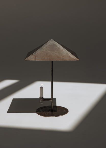 Portavelas metálico con forma de lámpara.