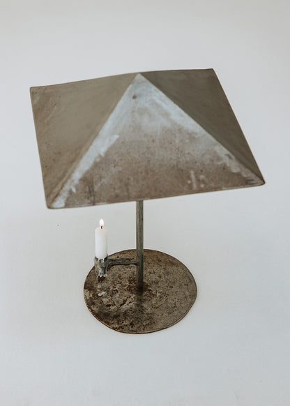 Portavelas metálico con forma de lámpara.