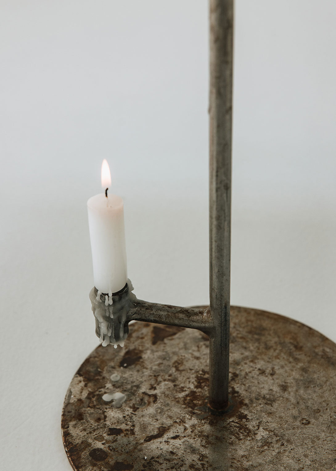 Portavelas metálico con forma de lámpara.