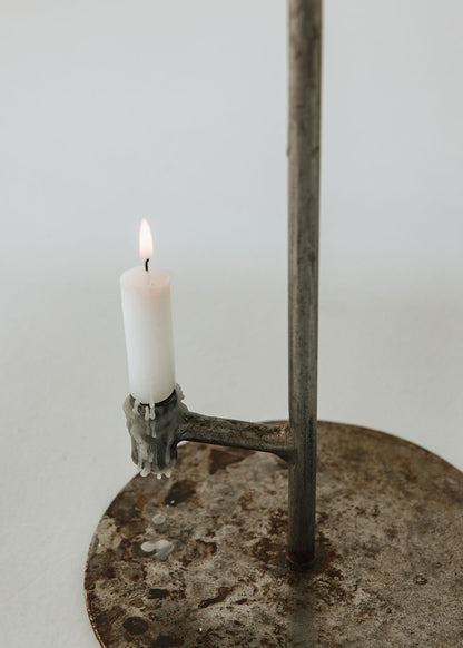 Portavelas metálico con forma de lámpara.