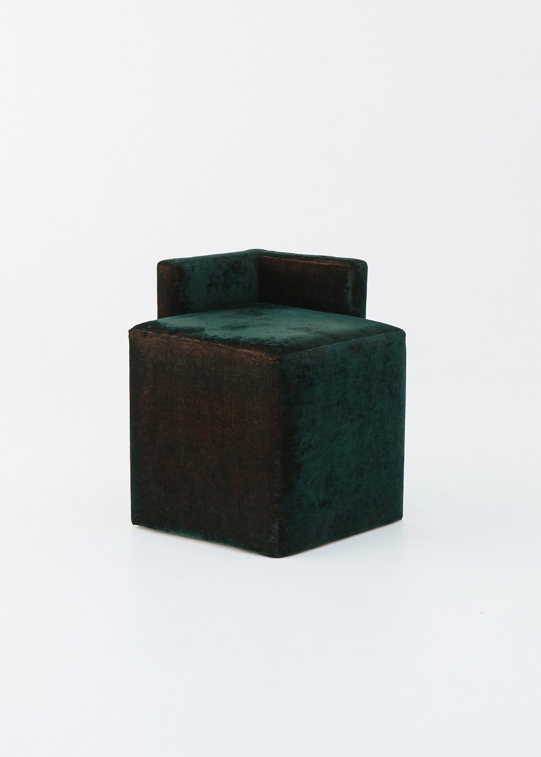 Puf cuadrado tapizado en terciopelo azul con detalle de flecos en la parte inferior.