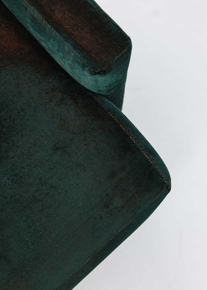 Puf cuadrado tapizado en terciopelo azul con detalle de flecos en la parte inferior.