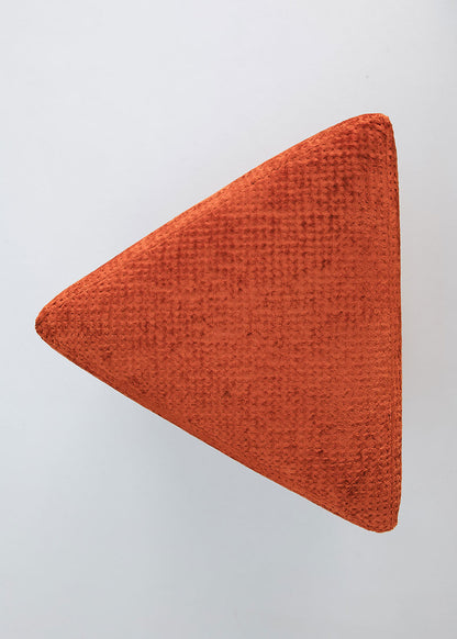 Puf triangular tapizado en tejido en tonos rojos, morados y burdeos.
