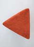 Puf triangular tapizado en tejido en tonos rojos, morados y burdeos.