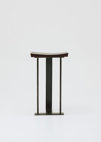 Taburete con estructura de hierro y asiento de madera de roble.