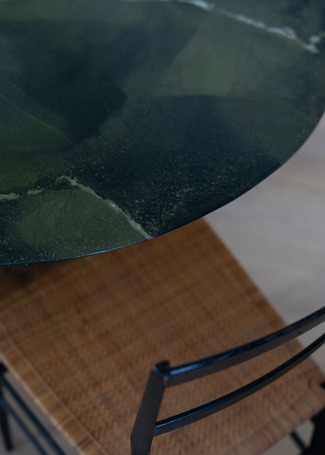 Mesa de comedor de cuarcita Avocatus con borde en pico de flauta y pie de metal oxidado con acabado martilleado y capa protectora.