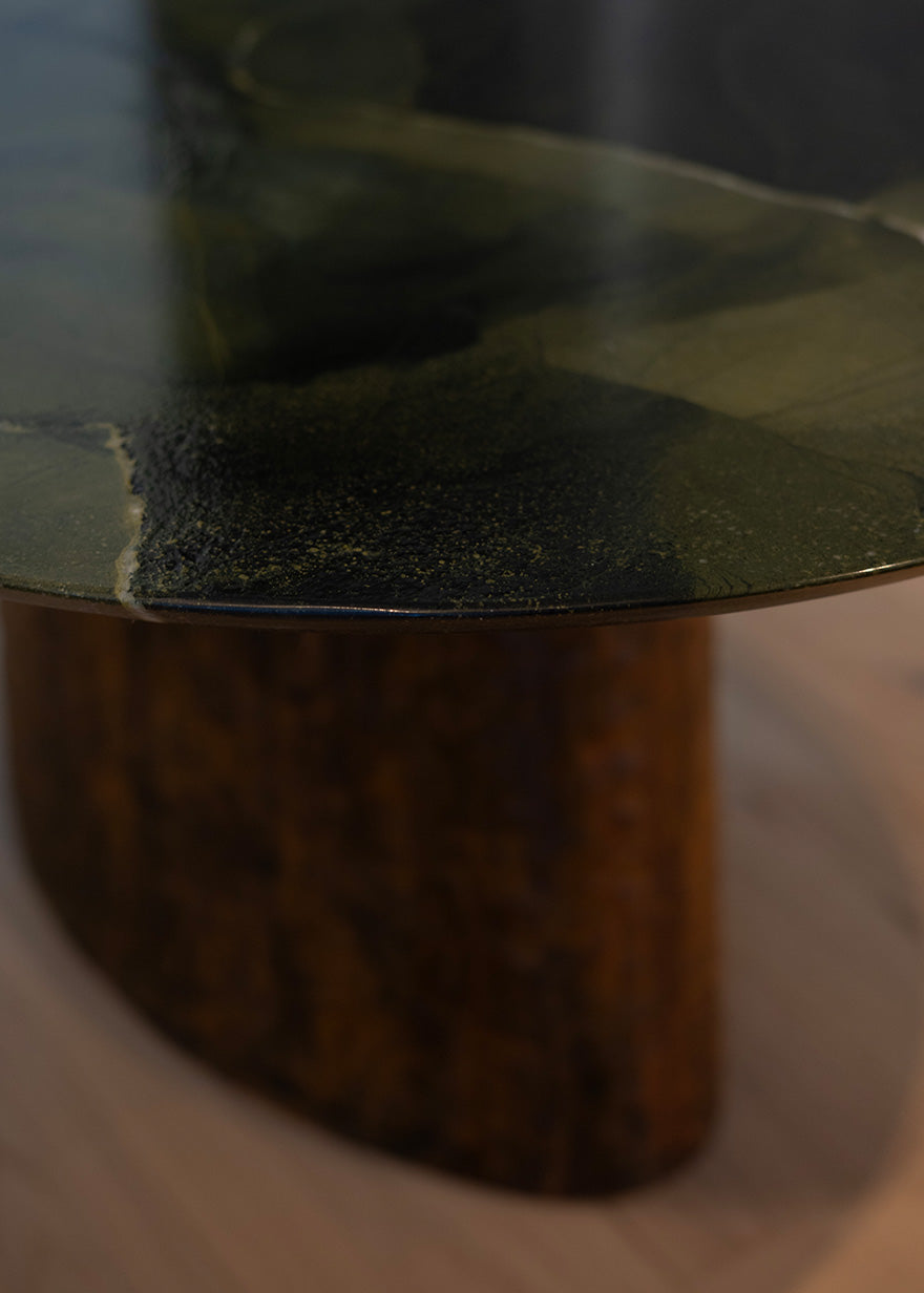 Mesa de comedor de cuarcita Avocatus con borde en pico de flauta y pie de metal oxidado con acabado martilleado y capa protectora.