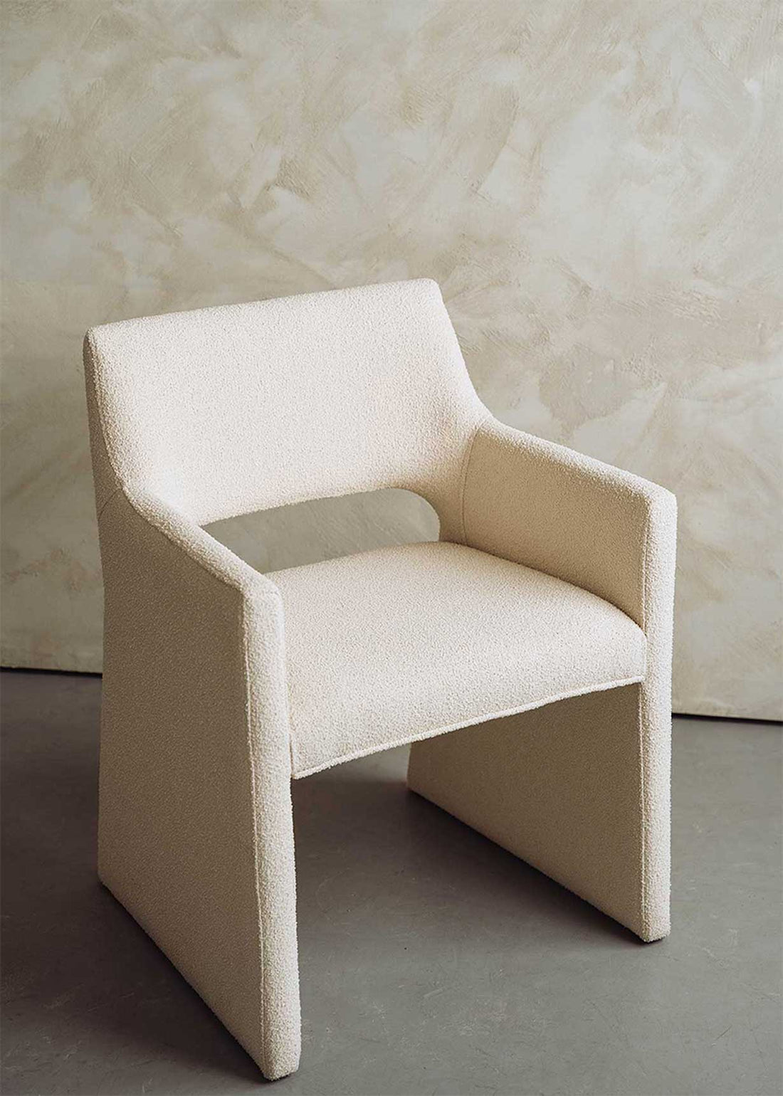 Butaca tapizada en tela beige.