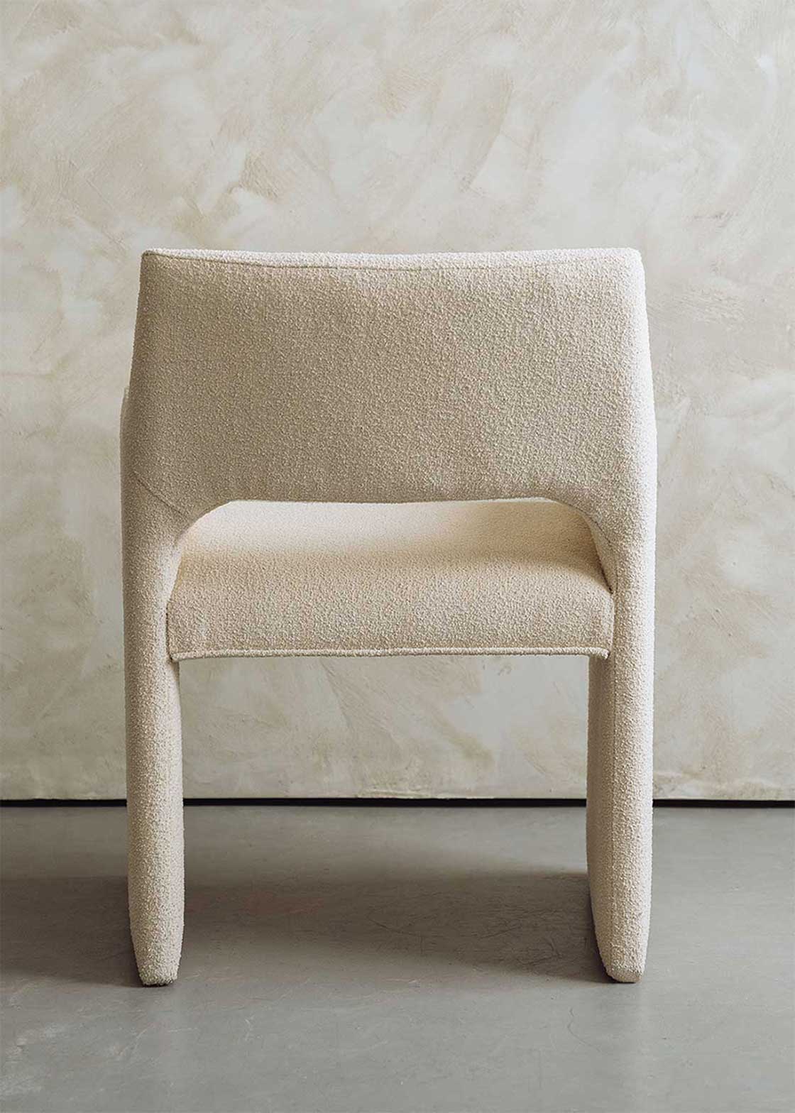 Butaca tapizada en tela beige.