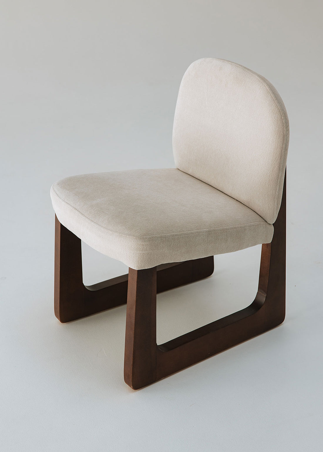 Silla de madera de haya tapizada en terciopelo beige.
