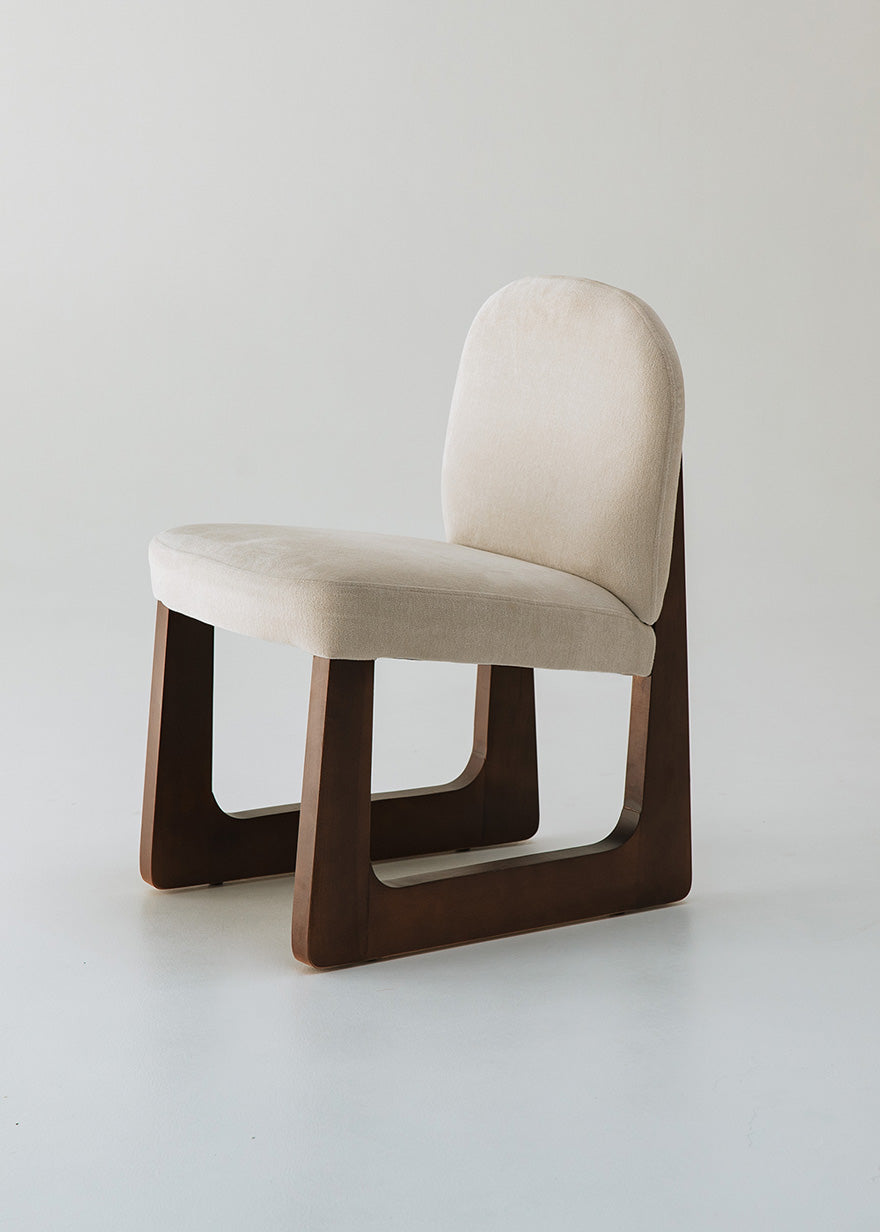 Silla de madera de haya tapizada en terciopelo beige.